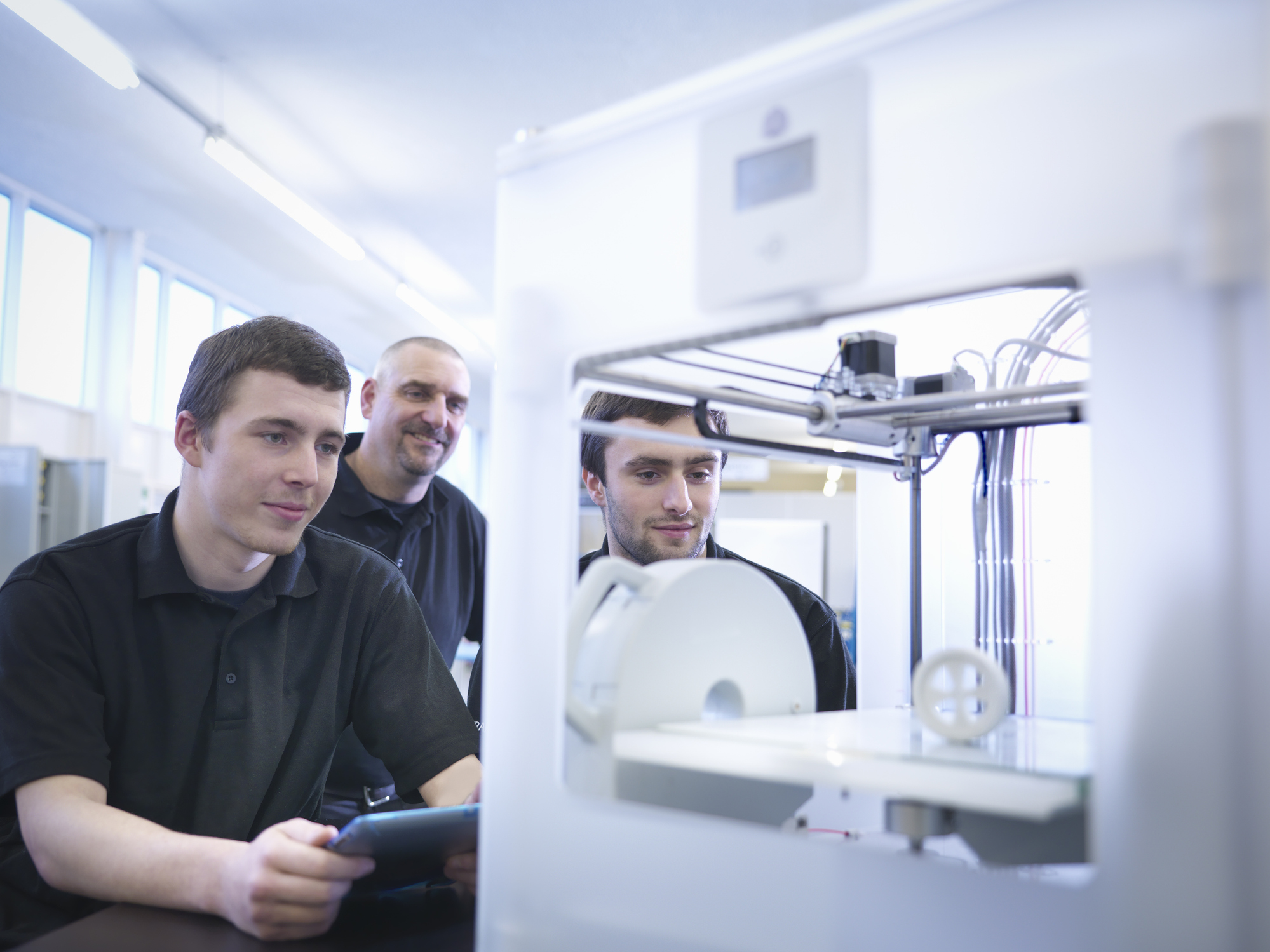 Instructor with apprentices and 3D printing machine